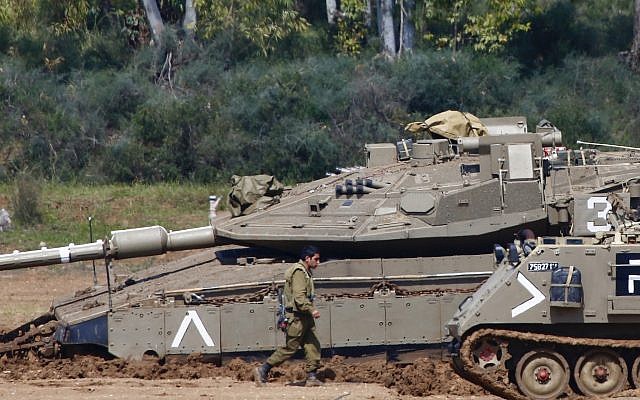Israeli soldiers work next to their tanks near the Israel Gaza border, Israel, Tuesday, March 26, 2019. (AP Photo/Ariel Schalit) Israeli soldiers work next to their tanks near the Israel Gaza border, Israel, Tuesday, March 26, 2019. (AP Photo/Ariel Schalit)