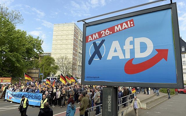 AfD supports walks along a party elections poster in Erfurt, Germany, Wednesday, May 1, 2019. (AP Photo/Jens Meyer) AfD supports walks along a party elections poster in Erfurt, Germany, Wednesday, May 1, 2019. (AP Photo/Jens Meyer)