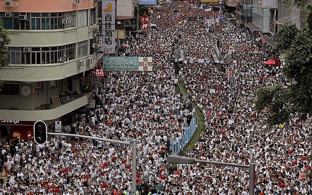 Protesters march along a downtown street against the proposed amendments to an extradition law in Hong Kong, June 9, 2019. (AP Photo/Vincent Yu)