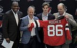 New Jersey Devils forward Jack Hughes, center right, the No. 1 overall pick in the 2019 NHL draft, poses for photographers with former NHL player Kevin Weekes, far left, Josh Harris, second from left, managing partner of Harris Blitzer Sports & Entertainment, and Ray Shero, Devils executive vice president and general manager, during a news conference introducing the prospect to local media, Tuesday, June 25, 2019, in Newark, N.J. (AP Photo/Julio Cortez)