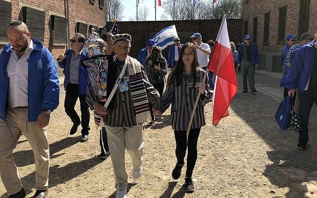 Edward Mosberg, holding a Torah scroll, during March of the Living in 2017 at the former death camp Auschwitz in Poland. (Courtesy of From the Depths via JTA) Edward Mosberg, holding a Torah scroll, during March of the Living in 2017 at the former death camp Auschwitz in Poland. (Courtesy of From the Depths via JTA)