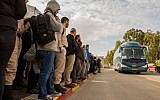 Israelis wait for a shuttles to Tel Aviv at the Beit Yehoshua train station, February 19, 2018 (Flash90)