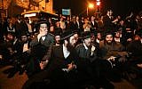 Ultra-Orthodox Jewish men block a road during a protest against the arrest of ultra-Orthodox Jewish women who failed to comply with a recruitment order, in Jerusalem, June 24, 2019. (Noam Revkin Fenton/Flash90)