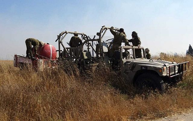 IDF soldiers help firefighters battle brushfires near the Gaza border started by an incendiary device launched from the Gaza Strip, on June 24, 2019. (Yankele Grossfeld/Sha'ar Hanegev Regional Council)