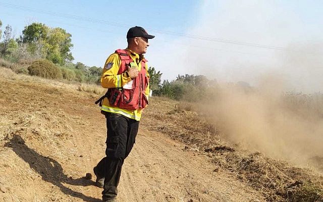 A firefighters battles a brushfire in southern Israel near the Gaza border that was started by an incendiary device launched from the Gaza Strip on June 24, 2019. (Yankele Grossfeld/Sha'ar Hanegev Regional Council)