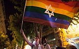 A woman waves a Jewish Pride flag in Jerusalem on August 1, 2015. (Omer Messinger/NurPhoto via Getty Images via JTA)