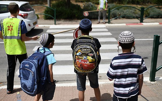 School children standing in front of a crosswalk after leaving school in Beit El, May 1, 2019. (Gili Yaari /Flash90)