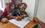 Palestinians receive financial aid from Qatar at a post office in Gaza City, June 20, 2019. (Abed Rahim Khatib/Flash90)