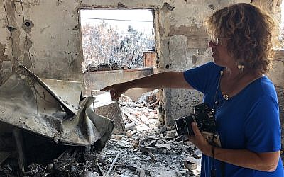 Zelda Burkey points to what remains of her home in Mevo Modi'im, which was destroyed along with much of the village in a fire in May 2019. (Sam Sokol/JTA)