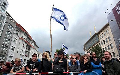 An Israeli flag flies above pro-Israel demonstrators protesting against an al-Quds Day rally in Berlin, July 25, 2014. (AP Photo/Markus Schreiber)