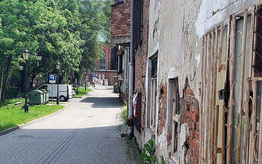 Former 'Jewish Street' in Oswiecim, Poland; the facade of the Great Synagogue was located near the grass, May 2019 (Matt Lebovic/The Times of Israel)
