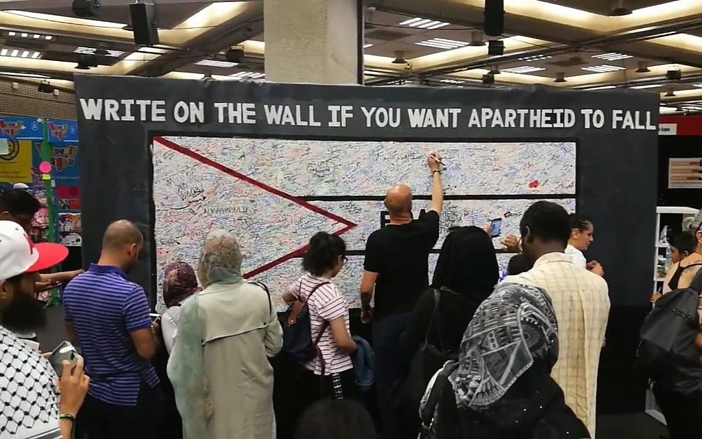 Attendees at Palestine Expo 2017 in London write on a wall to protest Israeli 'apartheid.' (Screenshot YouTube) Attendees at Palestine Expo 2017 in London write on a wall to protest Israeli 'apartheid.' (Screenshot YouTube)