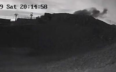 Smoke seen billowing from the landing site of a rocket fired from Syrian territory at Mount Hermon in the Golan Heights on June 1, 2019. (Screenshot from Mt. Hermon ski site CCTV)