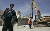Illustrative: Israeli police stand near an excavator as it demolishes a Palestinian home in the East Jerusalem neighborhood of Sur Baher on April 7, 2009. (Kobi Gideon/Flash90)