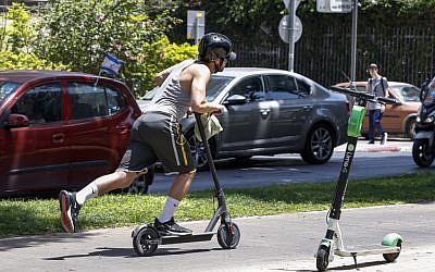 A man rides an electric scooter in the streets of Tel Aviv on May 30, 2019. (Jack Guez/AFP)