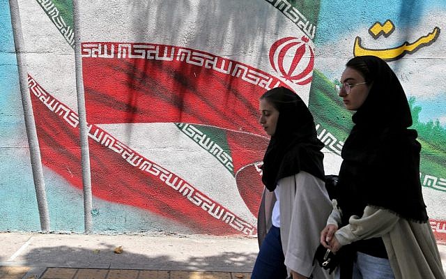 Iranian women walk past a mural painted with the Iranian flag in Tehran on June 25, 2019. (ATTA KENARE / AFP) Iranian women walk past a mural painted with the Iranian flag in Tehran on June 25, 2019. (ATTA KENARE / AFP)