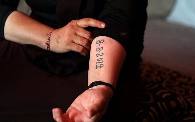 An Iraqi Yazidi survivor displays a tattoo bearing the date fighters from the Islamic State group entered the village of Sinjar, at her tent in the Khonke camp for displaced persons in northwestern Iraq on June 24, 2019. (SAFIN HAMED/AFP) An Iraqi Yazidi survivor displays a tattoo bearing the date fighters from the Islamic State group entered the village of Sinjar, at her tent in the Khonke camp for displaced persons in northwestern Iraq on June 24, 2019. (SAFIN HAMED/AFP)