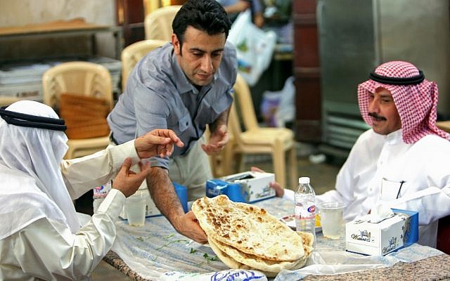 A waiter serves Iranian bread - known as taftoon - at the Al-Walimah restaurant in Kuwait City on June on June 27, 2019. - Iranian bread has for decades been a staple of Kuwaiti breakfast, lunch and dinner tables. For Kuwaitis, their bond with Iranian culture remains unchanged despite the growing regional tensions between the Sunni-ruled Gulf countries and the Shiite Islamic republic. (Photo by Yasser Al-Zayyat / AFP) A waiter serves Iranian bread - known as taftoon - at the Al-Walimah restaurant in Kuwait City on June on June 27, 2019. - Iranian bread has for decades been a staple of Kuwaiti breakfast, lunch and dinner tables. For Kuwaitis, their bond with Iranian culture remains unchanged despite the growing regional tensions between the Sunni-ruled Gulf countries and the Shiite Islamic republic. (Photo by Yasser Al-Zayyat / AFP)