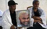 Worka and Wbjig Tekah hold a picture of their son Solomon Tekah, 19, who was killed by an off duty police officer, at their home in the Israeli city of Haifa, on July 3, 2019. (Menahem Kahana/AFP)