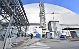 A picture shows the  New Safe Confinement (NSC) new metal dome designed and built by French consortium Novarka encasing the destroyed reactor at Chernobyl plant on July 10, 2019, in Chernobyl. - Ukraine and its European partners on July 10 formally inaugurated a new metal dome encasing the destroyed reactor at the infamous Chernobyl plant, wrapping up a two-decade effort. Branded as the world's largest moveable metal structure, the so-called New Safe Confinement seals the remains of the fourth reactor at the nuclear plant that was the site of the massive Chernobyl disaster in 1986. (Photo by SERGEI SUPINSKY / AFP)