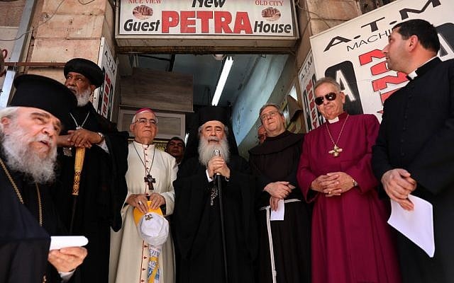 Greek Orthodox Patriarch of Jerusalem Theophilus III, center, together with the Franciscan Custodian of the Holy Land Fr Francesco Patton, center-right, and fellow church leaders from different denominations hold an ecumenical prayer outside the Petra hostel at Jaffa Gate in Jerusalem's Old City on July 11, 2019. (GALI TIBBON/AFP) Greek Orthodox Patriarch of Jerusalem Theophilus III, center, together with the Franciscan Custodian of the Holy Land Fr Francesco Patton, center-right, and fellow church leaders from different denominations hold an ecumenical prayer outside the Petra hostel at Jaffa Gate in Jerusalem's Old City on July 11, 2019. (GALI TIBBON/AFP)