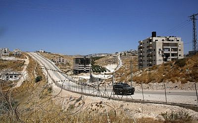 An Israeli police vehicle is seen driving past Palestinian buildings in Sur Baher slated for demolition, seen here from Beit Sahur in the West Bank. (Hazem Bader/AFP)