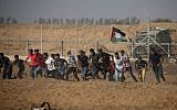 Palestinian demonstrators run away from the fence during protests along the border with Israel, east of Khan Younis, in the southern Gaza Strip on July 12, 2019. (Mahmud Hams/AFP)