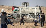 Palestinian demonstrators throw stones at Israeli security forces during protests along the border with Israel, east of Khan Younis, in the southern Gaza Strip on July 12, 2019. (MAHMUD HAMS / AFP)