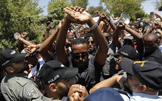 Ethiopian-Israelis protest outside the Knesset in Jerusalem on July 15, 2019, after the release of a police officer who shot and killed a young man of Ethiopian origin in Haifa on June 30. (Menahem Kahana/AFP) Ethiopian-Israelis protest outside the Knesset in Jerusalem on July 15, 2019, after the release of a police officer who shot and killed a young man of Ethiopian origin in Haifa on June 30. (Menahem Kahana/AFP)