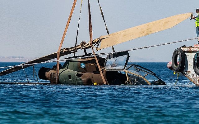 This picture taken on July 24, 2019 shows a decommissioned Jordanian Armed Forces' AH-1 Cobra helicopter being submerged into the waters of the Red Sea off the coast of the southern Jordanian port city of Aqaba, as part of preparations for a new underwater military museum. (Khalil MAZRAAWI / AFP)