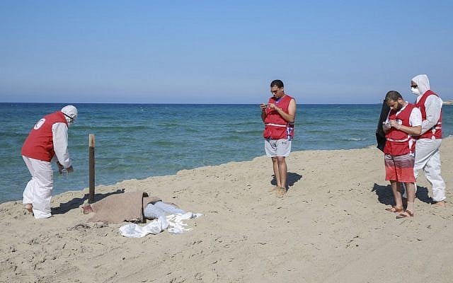 Members of the Libyan Red Crescent cover the washed up body of a migrant on the beach in Khoms, 120km east of the Libyan capital Tripoli, on July 26, 2019 (AFP) Members of the Libyan Red Crescent cover the washed up body of a migrant on the beach in Khoms, 120km east of the Libyan capital Tripoli, on July 26, 2019 (AFP)