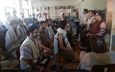 Illustrative: Students meditate as part of the morning prayer at Romemu Yeshiva in New York, July 16, 2019. The yeshiva combines intensive study of Jewish text with mindfulness and mysticism. (Ben Sales)