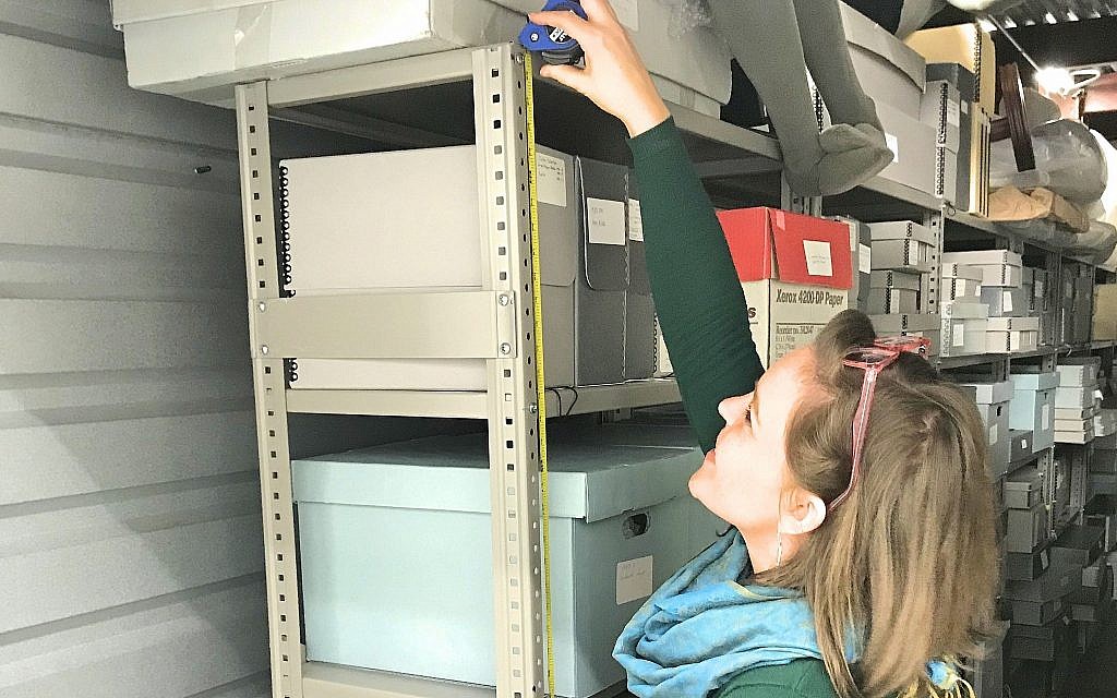 Museum of the Southern Jewish Experience project coordinator, Anna Tucker, measures shelves used to store artifacts ahead of the move last month. (Courtesy of the Museum of the Southern Jewish Experience)