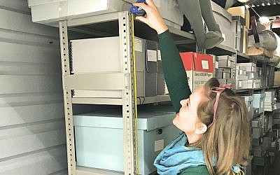 Museum of the Southern Jewish Experience project coordinator, Anna Tucker, measures shelves used to store artifacts ahead of the move last month. (Courtesy of the Museum of the Southern Jewish Experience)