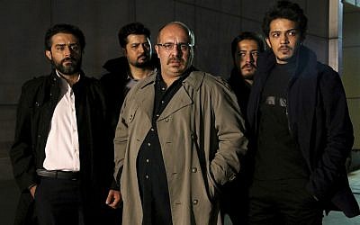 An undated promotional handout still from the Iranian state TV series, 'Gando,' shows actor Payam Dehkordi, center, who plays a character apparently based on Washington Post journalist Jason Rezaian, among other actors. (Mohammad Bagheri/TV series, 'Gando,' via AP)