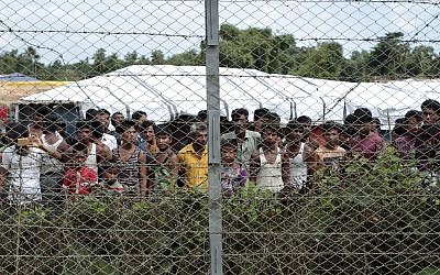 Rohingya refugees gather near a fence during a government organized media tour to a no-man's land between Myanmar and Bangladesh, near Taungpyolatyar village, Maung Daw, northern Rakhine State, Myanmar, June 29, 2018. (Min Kyi Thein/AP)