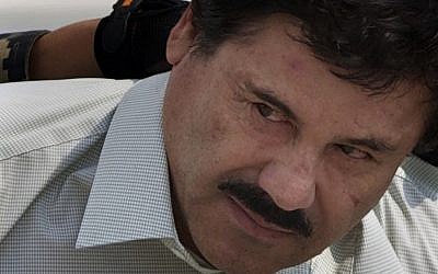 In this February 22, 2014, file photo, Joaquin 'El Chapo' Guzman is escorted to a helicopter in handcuffs by Mexican navy marines at a navy hanger in Mexico City. (AP Photo/Eduardo Verdugo, File)