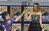 Director Taika Waititi hands the Thor hammer to Natalie Portman during the "Thor Love And Thunder" portion of the Marvel Studios panel on day three of Comic-Con International on July 20, 2019, in San Diego. (Chris Pizzello/Invision/AP)