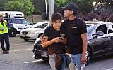 A young couple embrace at a parking lot after a shooting at the Gilroy Garlic Festival in Gilroy, California, Sunday, July 28, 2019 (AP Photo/Thomas Mendoza)