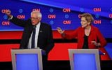 Senator Bernie Sanders (Independent-Vermont) and Senator Elizabeth Warren (Democrat-Massachusetts) talk during in the first of two Democratic presidential primary debates hosted by CNN July 30, 2019, in the Fox Theatre in Detroit. (AP Photo/Paul Sancya)