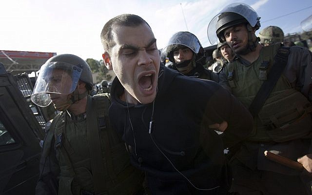 Left-wing activist Jonathan Pollak is detained by Israeli soldiers during a protest over a disputed water well in the West Bank village of Nabi Saleh near Ramallah, January 22, 2010. (AP Photo/Bernat Armangue) Left-wing activist Jonathan Pollak is detained by Israeli soldiers during a protest over a disputed water well in the West Bank village of Nabi Saleh near Ramallah, January 22, 2010. (AP Photo/Bernat Armangue)