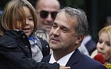 New Transport and Infrastructure Minister Makis Voridis, member of the right-wing party LAOS, arrives at the Presidential Palace holding his son in Athens on November 11, 2011. (Dimitri Messini/AP)
