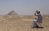A member of an international delegation sketches the site of the Bent Pyramid during an event opening the pyramid and its satellites for visitors in Dashur, Egypt, Saturday, July 13, 2019 (AP Photo/Maya Alleruzzo)