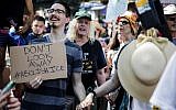 People holds hands as they chant at a rally before the start of a march in opposition to the Trump administration's plans to continue with raids to catch immigrants in the country illegally, July 14, 2019, in the Queens borough of New York. (AP Photo/Julius Constantine Motal)