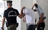 Israeli suspects cover their faces with their shirts as they arrive at the Famagusta courthouse in Paralamni, Cyprus, July 26, 2019 (AP Photo/Petros Karadjias)