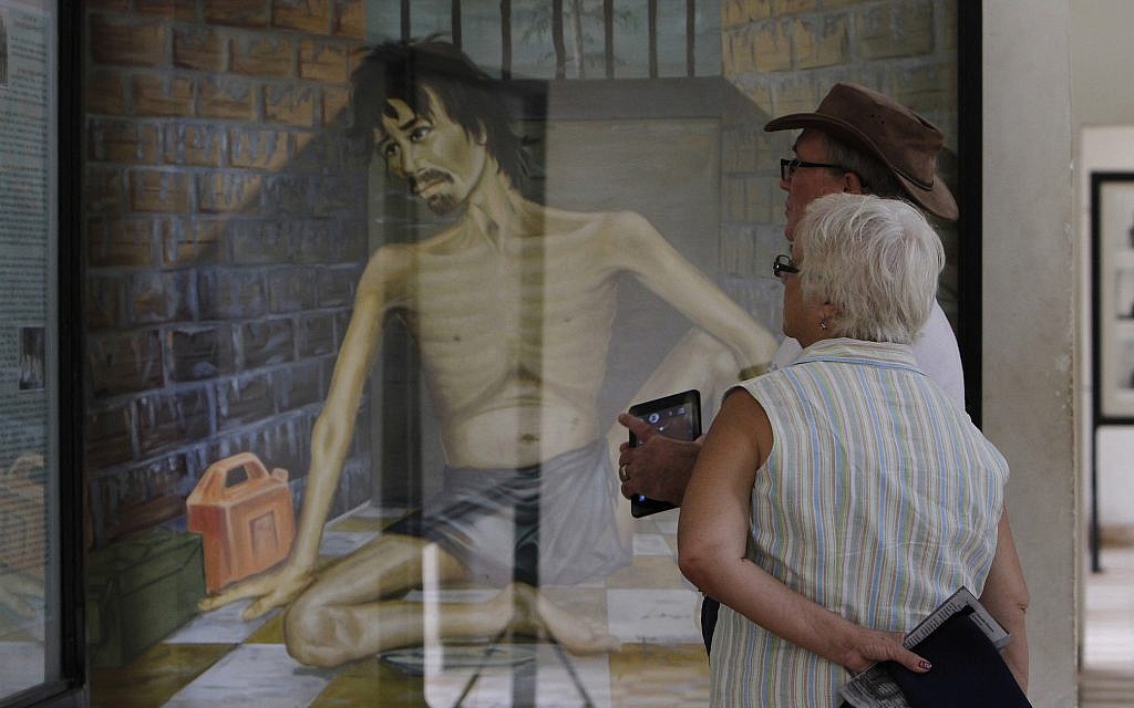 Illustrative: In this July 10, 2014 photo, tourists look at a painting depicting Khmer Rouge torture at the Tuol Sleng Genocide Museum, formerly the most notorious Khmer Rouge prison, in Phnom Penh, Cambodia. (AP Photo/Heng Sinith)
