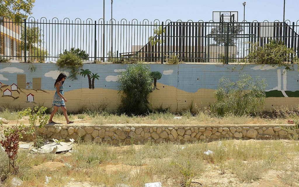 A young woman walks by a mural in a Yerucham garden on June 28, 2014.  (Zoe Vayer/Flash90.)