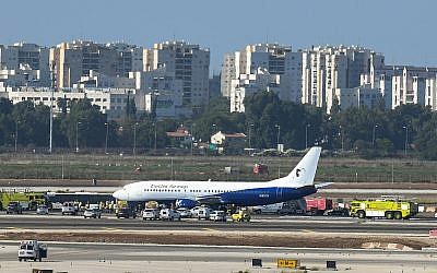 Rescuers reach a damaged Boeing 737 plane on the runway at Ben Gurion Airport shortly after it lands safely, despite a blown tire, on July 1, 2019. (Flash90)