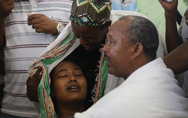 Worka Tekah (R), the father of Solomon Tekah, 19, who was shot dead by a police officer, at his son's funeral in Kiryat Haim as a woman comforts his daughter (L), July 2 2019 (Yonatan Sindel/Flash90) Worka Tekah (R), the father of Solomon Tekah, 19, who was shot dead by a police officer, at his son's funeral in Kiryat Haim as a woman comforts his daughter (L), July 2 2019 (Yonatan Sindel/Flash90)
