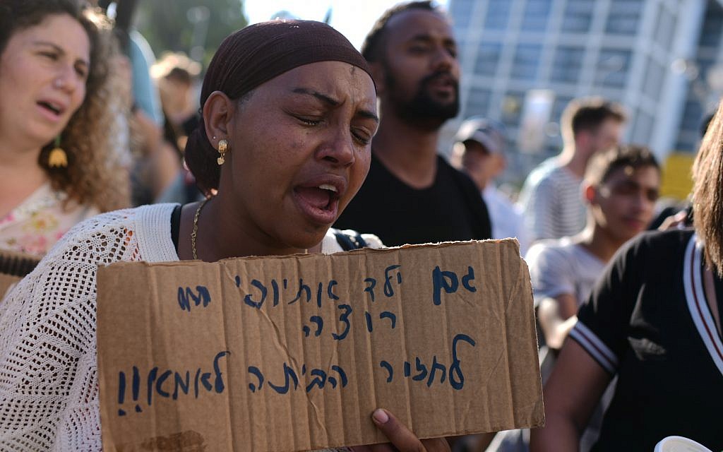 Ethiopian-Israelis and supporters take part in a protest against police violence and discrimination following the death of 19-year-old Solomon Tekah, who was shot and killed on June 30 by an off-duty police officer, in Tel Aviv, July 3, 2019. The sign reads, "An Ethiopian child also wants to get home to mother." (Tomer Neuberg/Flash90)